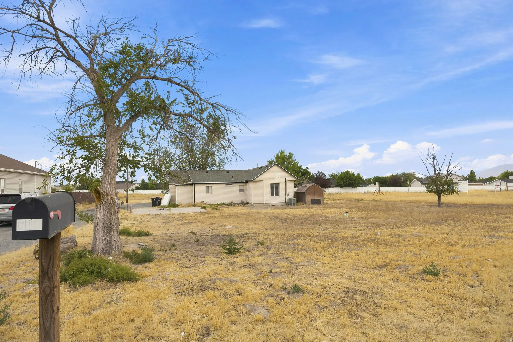 Expansive undeveloped lot with a single-story structure and a small accessory building