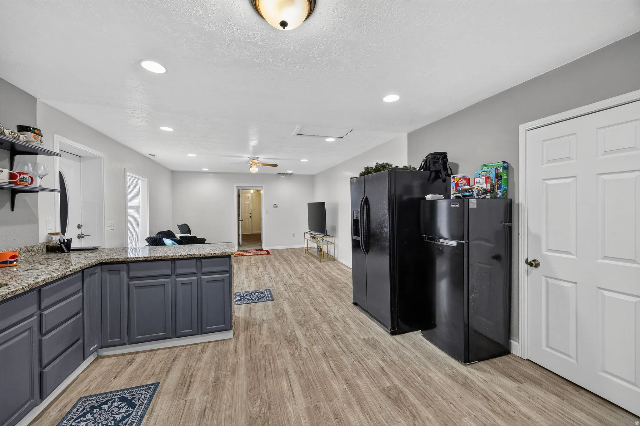 Open-concept living area featuring wood-finish flooring, recessed lighting, and a ceiling fan