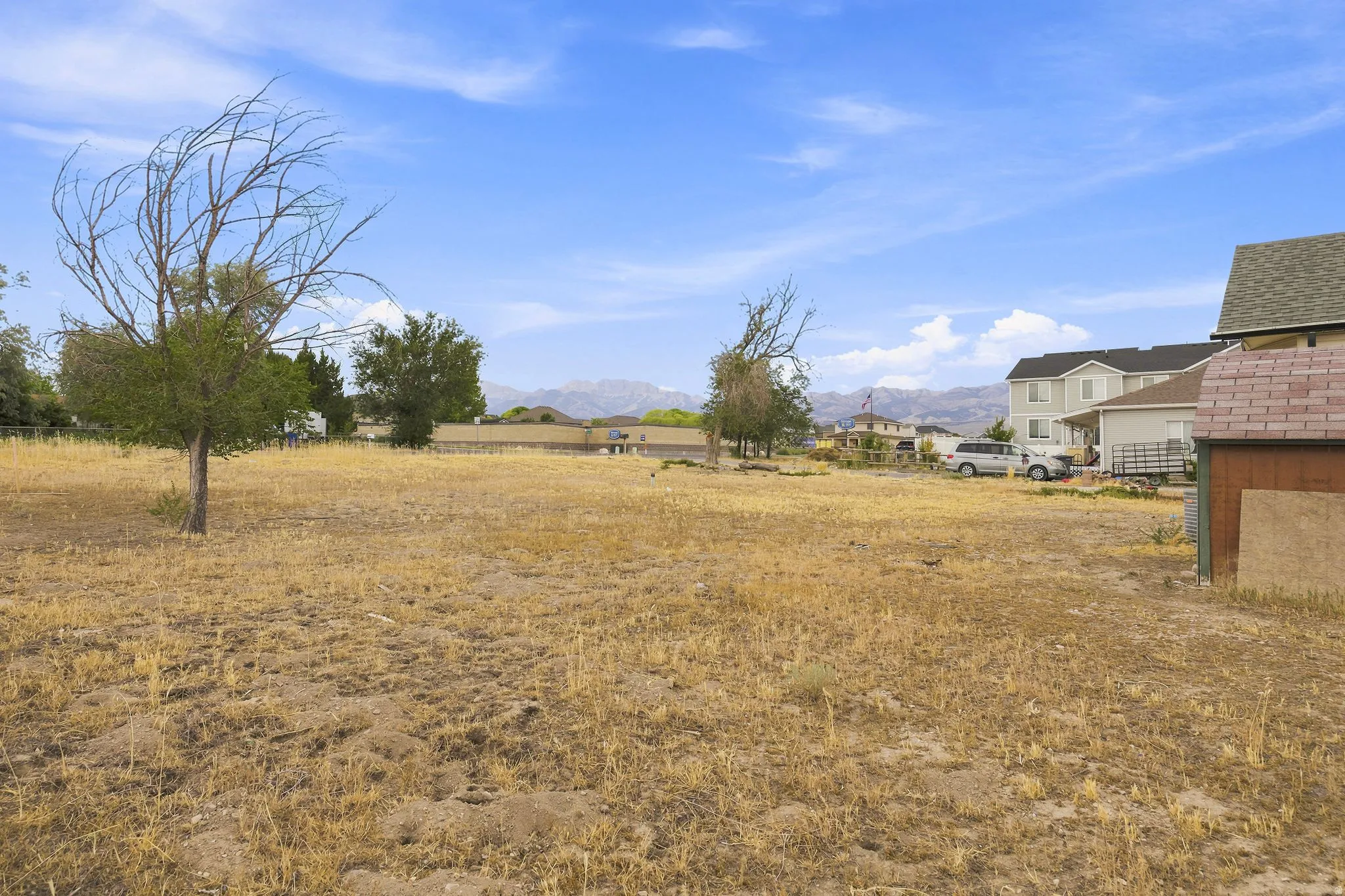 Expansive open lot featuring natural landscaping and distant mountain scenery