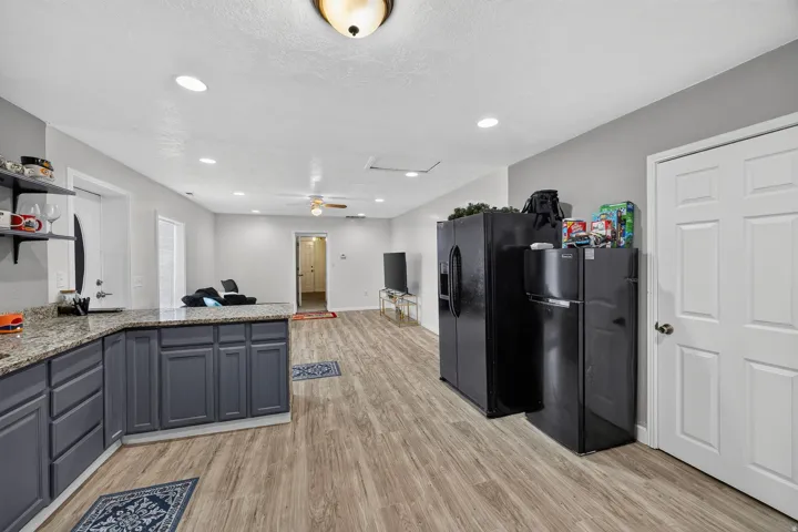 Open-concept living area featuring wood-finish flooring, recessed lighting, and a ceiling fan