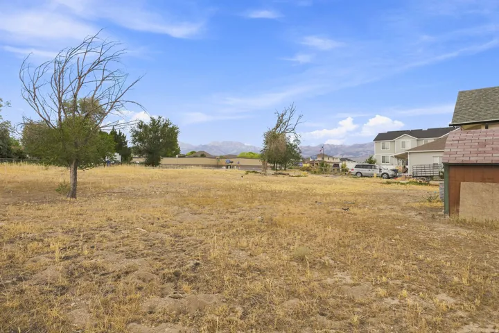 Expansive open lot featuring natural landscaping and distant mountain scenery