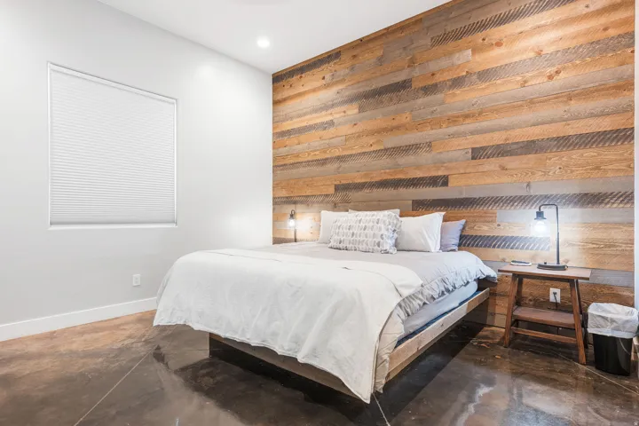 Accent wall featuring horizontal wood paneling, polished concrete flooring, recessed ceiling lighting, a single window with blinds, and clean white baseboards