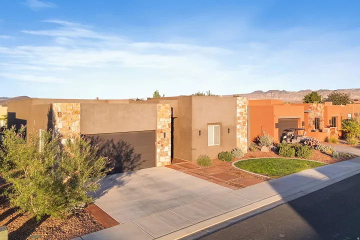 Modern stucco exterior featuring stone accents and an integrated garage