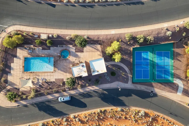 Community recreation area featuring a rectangular swimming pool, circular spa, and two tennis courts