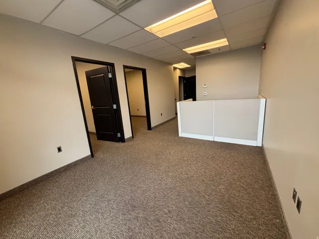 Office space featuring textured carpet flooring and neutral wall tones