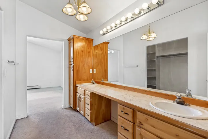 Dual vanity with integrated sinks, ample countertop space, and natural wood cabinetry