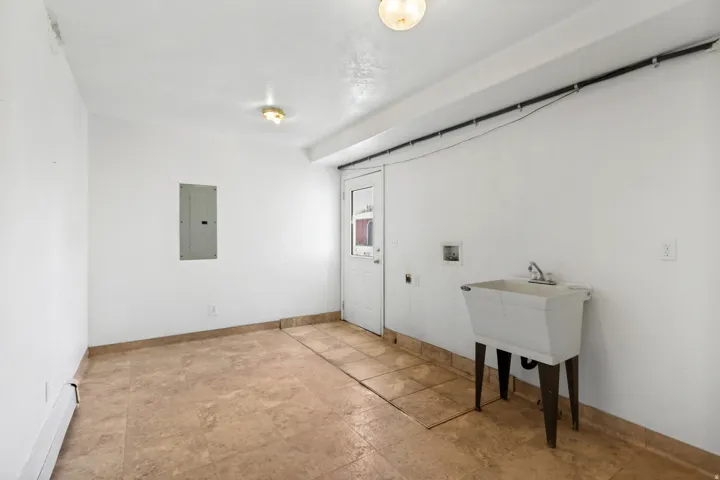 Utility room featuring tile flooring, a utility sink, and overhead lighting