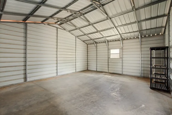 Spacious metal outbuilding featuring a corrugated metal roof, corrugated metal walls, concrete flooring, and a single window