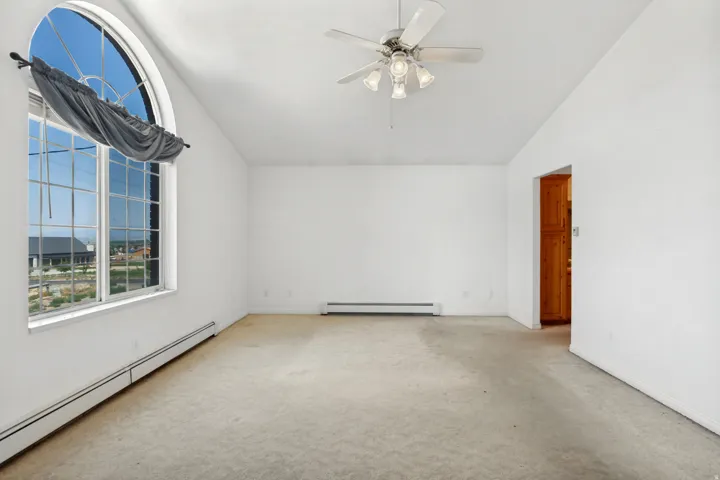 Vaulted ceilings featuring a ceiling fan with light fixture