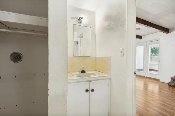 Vanity with integrated sink, chrome faucet, and mirrored medicine cabinet