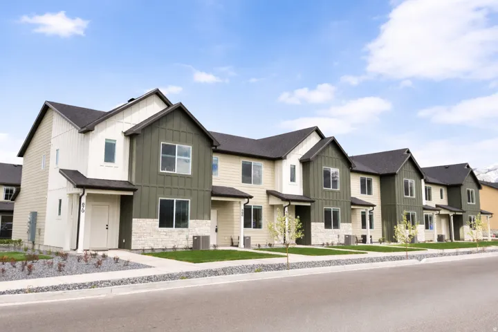 Modern townhome-style residences featuring contemporary architectural design with mixed exterior finishes in cream and sage green
