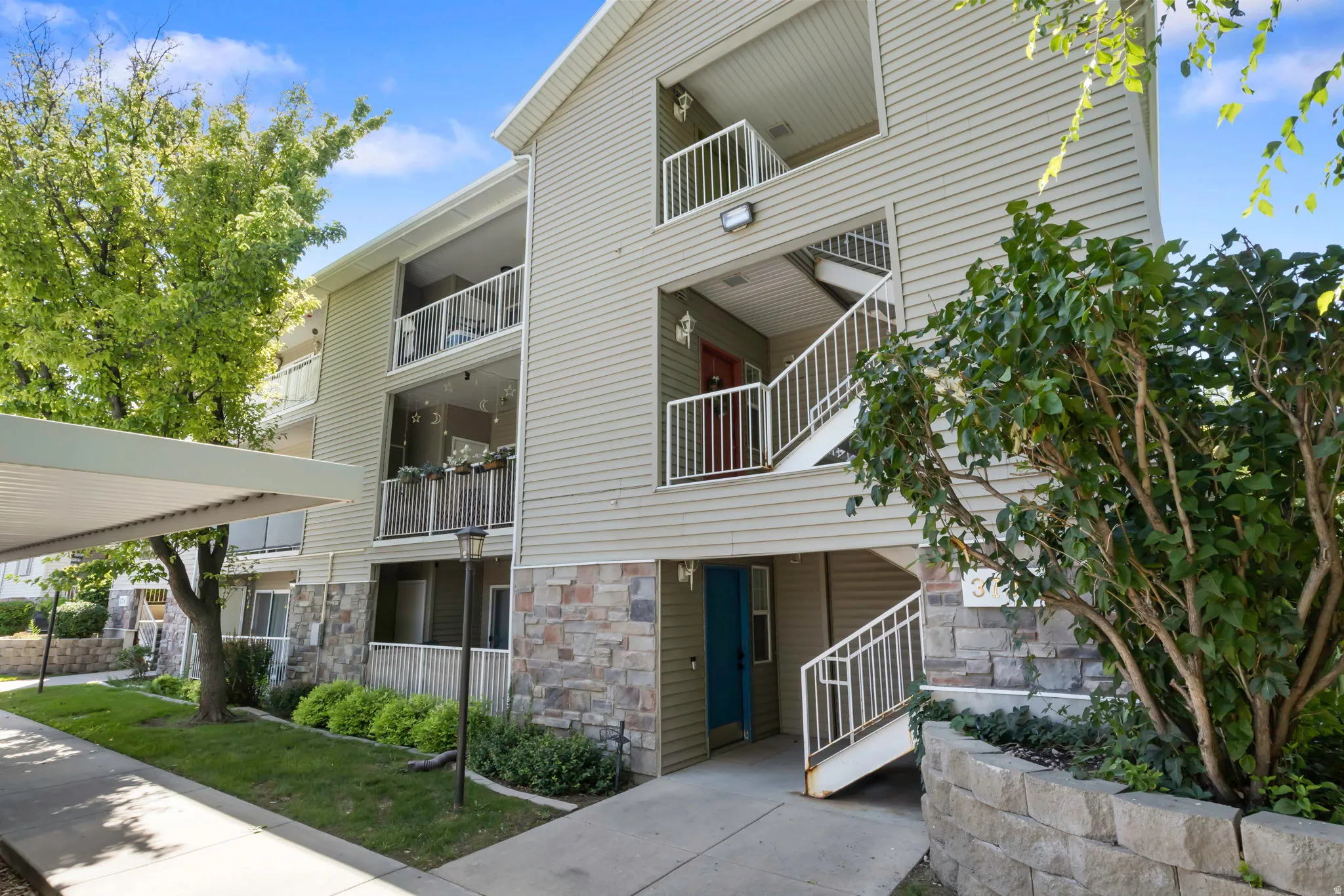 Multi-story building exterior featuring horizontal siding and a stone veneer base