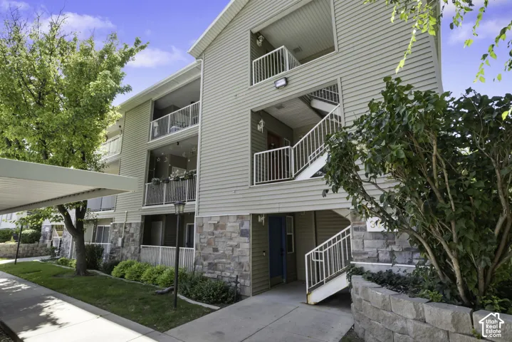 Multi-story building exterior featuring horizontal siding and a stone veneer base