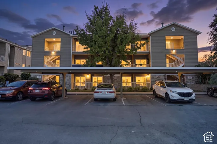 Multi-story residential building featuring balconies, exterior staircases, and ground-level patios