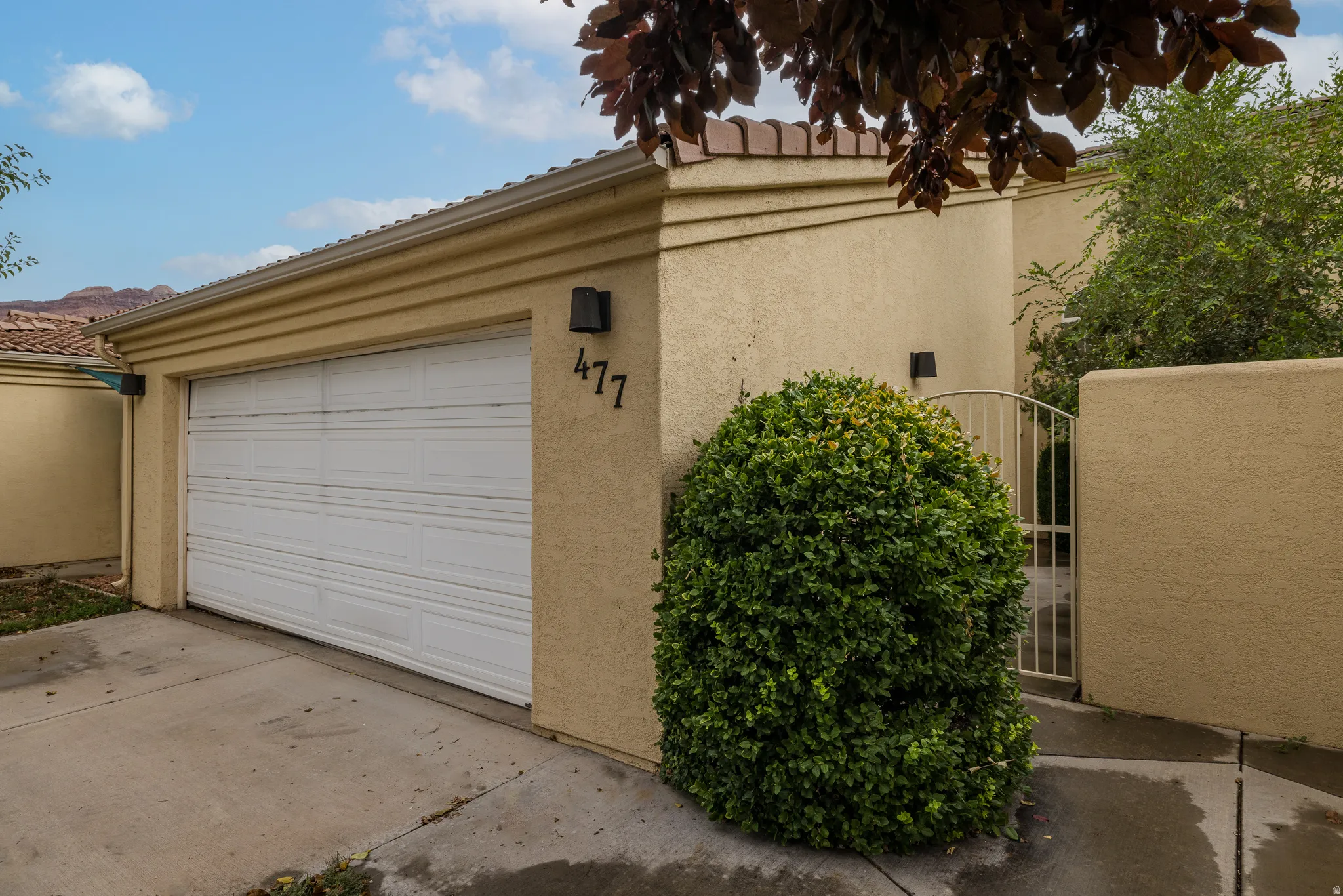 Attached garage, stucco exterior, and gated entry