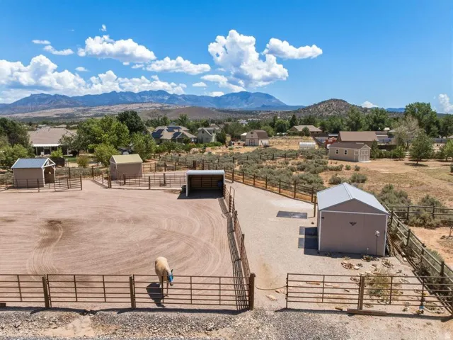 Expansive equestrian property featuring a large arena, multiple fenced paddocks, and dedicated outbuildings