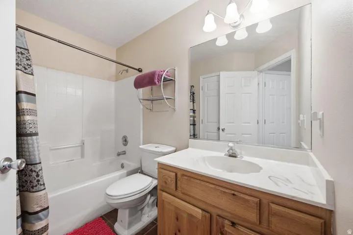 Bathroom featuring a vanity with a white countertop and integrated sink, wood-finish cabinetry, and an overhead lighting fixture