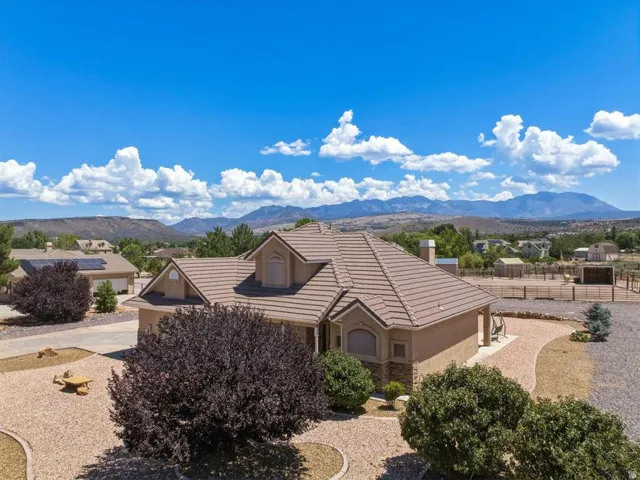 Southwestern style residence featuring a tile roof, stucco exterior, and stone accents