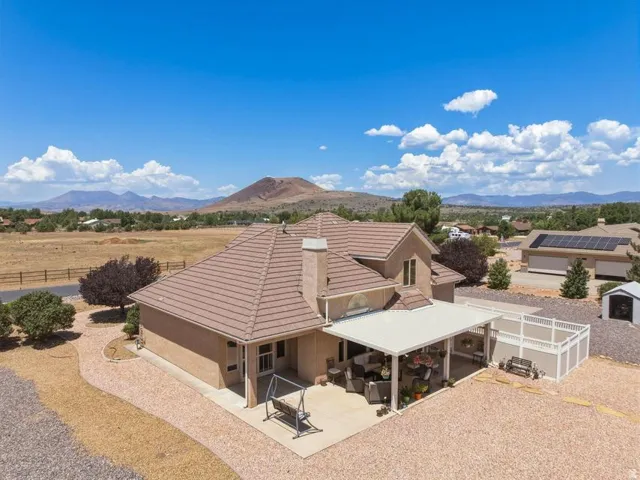 Expansive outdoor living area featuring a covered patio, a gravel yard, and a privacy fence