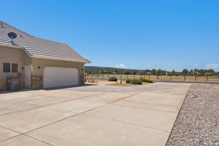 Exterior featuring a multi-panel garage door, stucco siding, and stone accents
