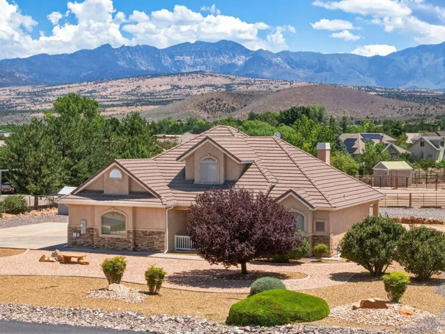 Stucco exterior with stone veneer accents, a tiled roof, and arched windows