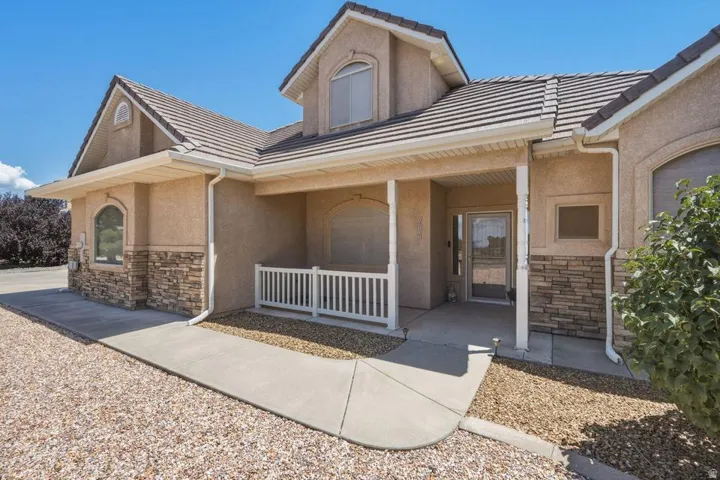 Stucco exterior with stone accents and a covered front porch