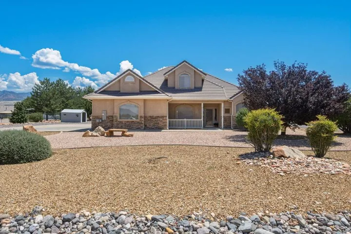Stucco exterior with stone accenting and a covered porch