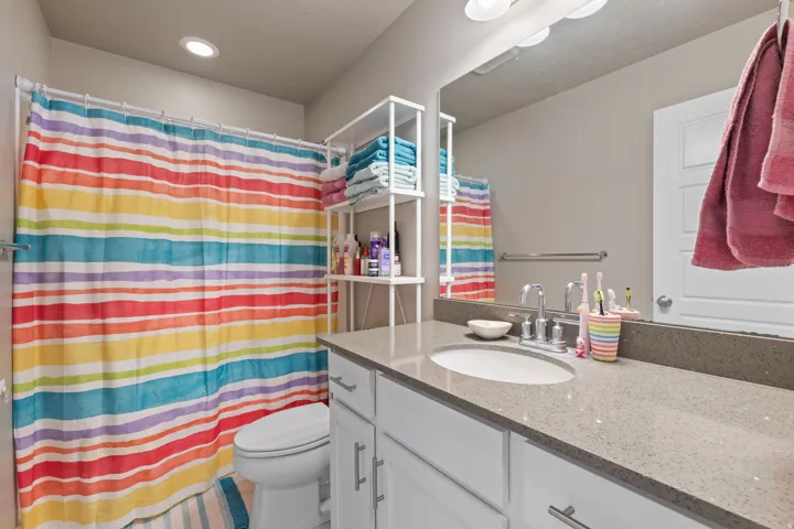 Vanity with an integrated sink and stone-finish countertop, brushed nickel faucet, and a large wall-mounted mirror