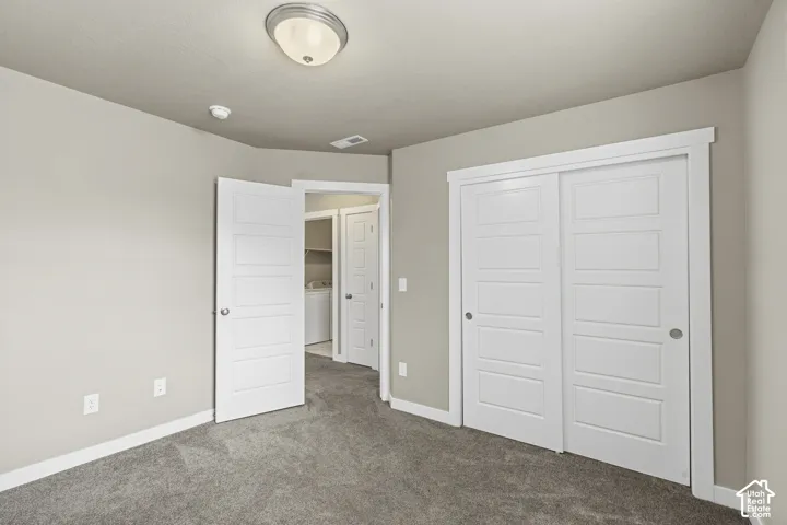 Neutral wall finishes, plush carpeting, white four-panel interior doors, sliding closet doors, and a flush-mount ceiling light fixture