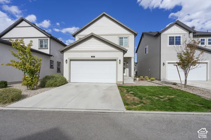 Two-story exterior featuring a stucco and horizontal siding facade, a front-facing attached garage, and concrete driveway