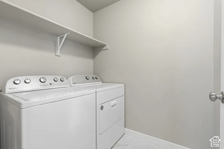 Laundry area featuring a built-in overhead shelf and stone-pattern tile flooring
