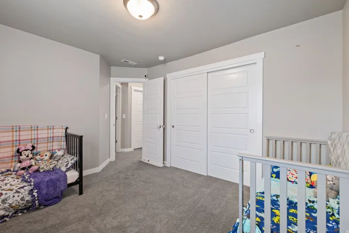 Neutral wall paint, plush carpeting, white trim, sliding closet doors, and recessed lighting