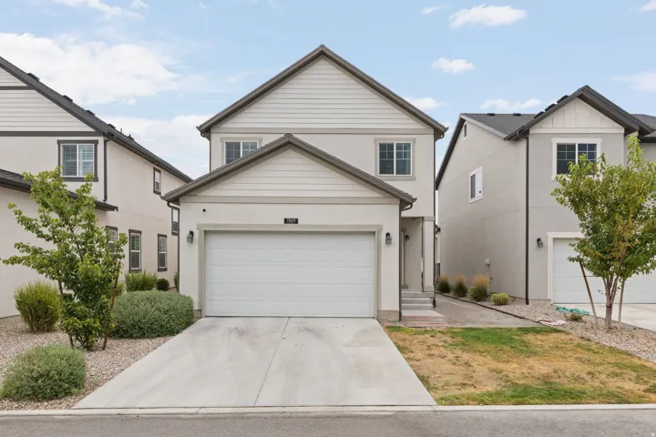 Two-story residence with a two-car garage, stucco exterior, and gable roof