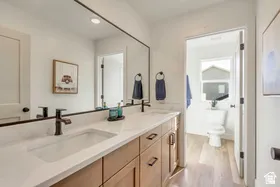 Double vanity with light wood-finish cabinetry and white countertops