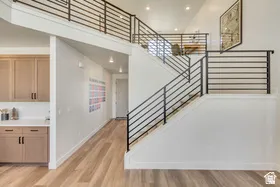 Two-story interior with a prominent staircase featuring horizontal black metal railings