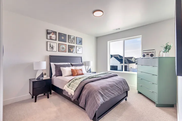 Spacious bedroom with light-colored carpet flooring and white walls