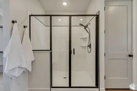 Shower enclosure featuring black-framed glass and white shower panels with built-in shelving