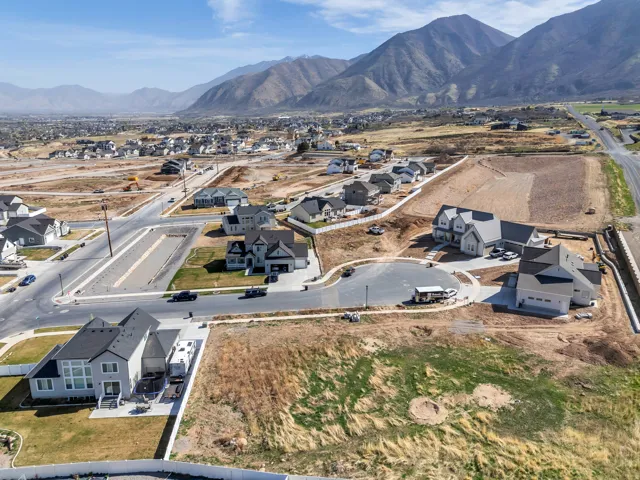 Newly constructed homes with varied architectural styles, asphalt roadways, and mountain backdrops