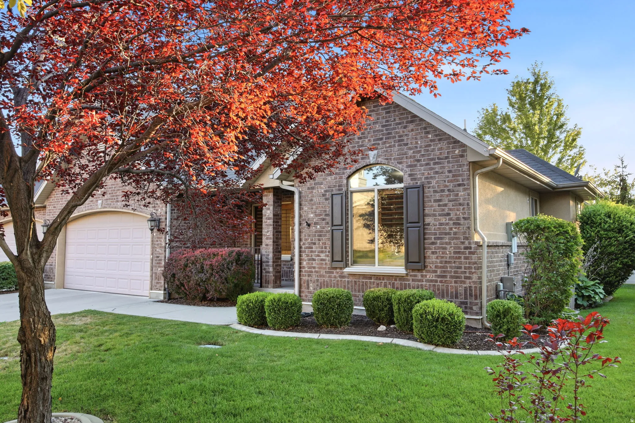 Brick exterior with an arched window featuring dark shutters