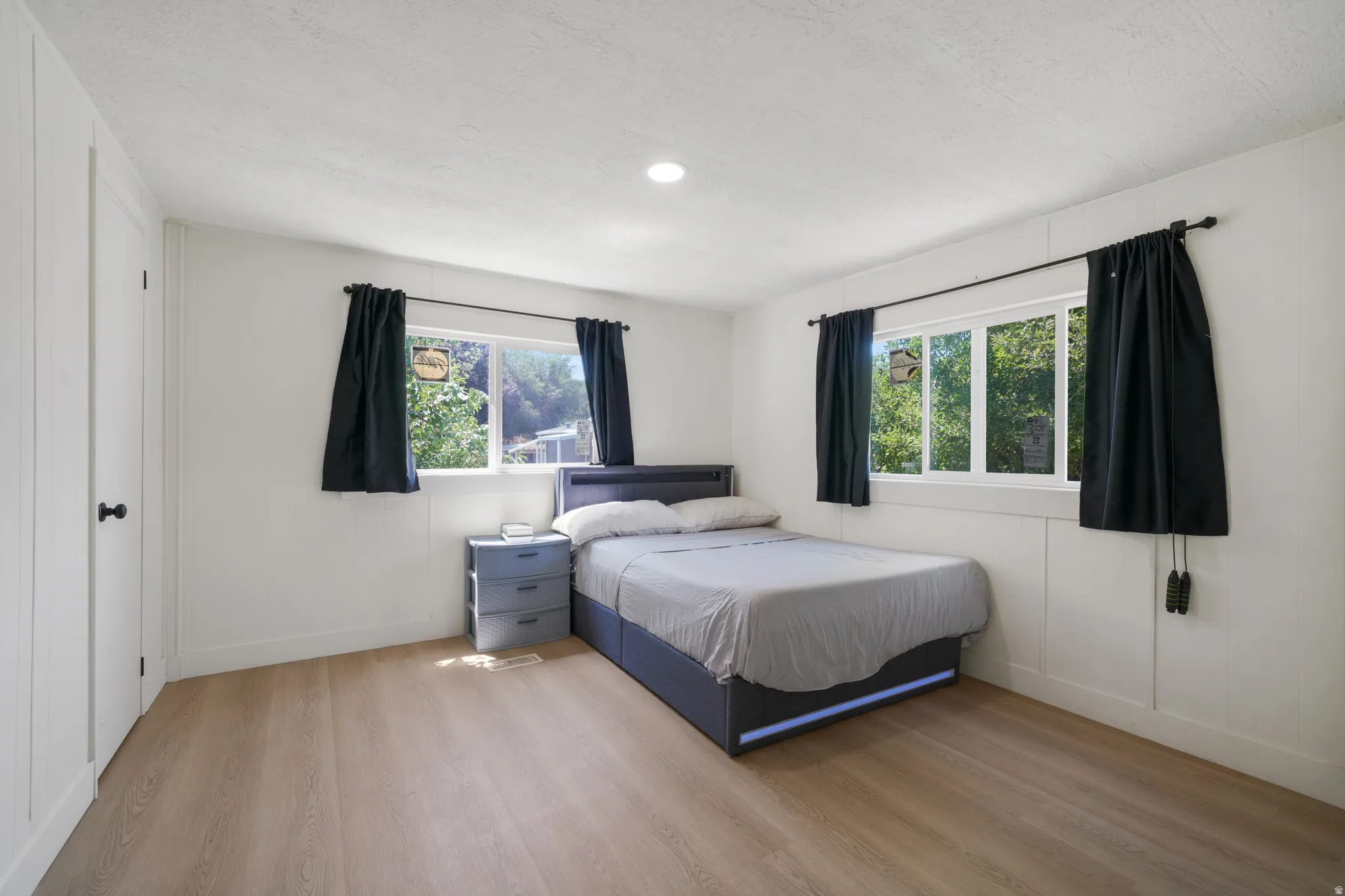 Bright room featuring light wood-finish flooring and white walls