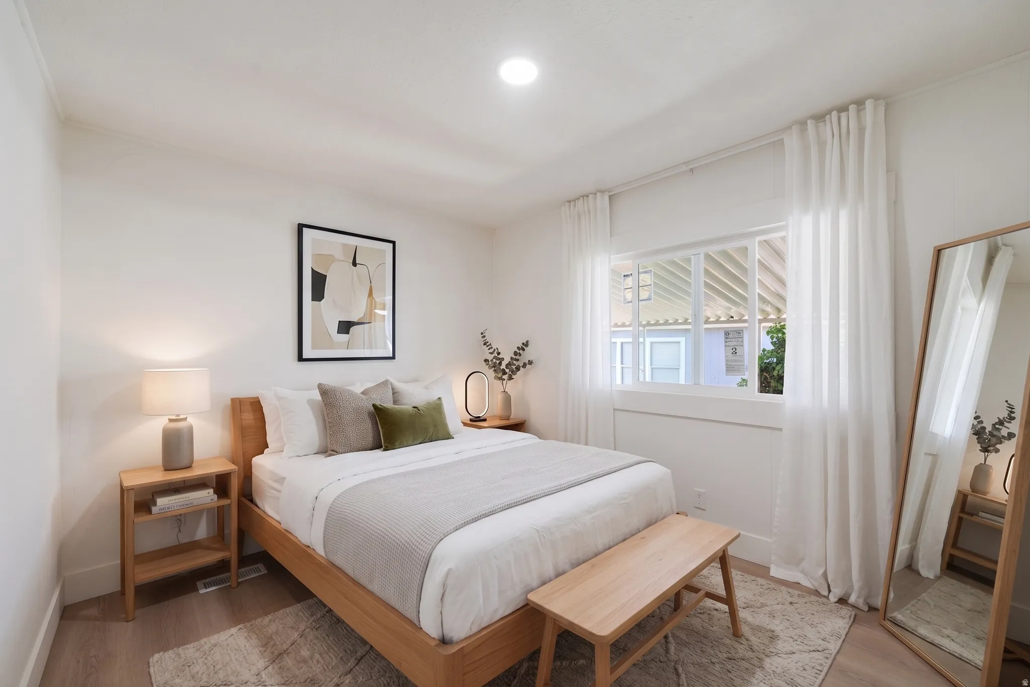 Bright bedroom featuring recessed lighting and a large window with white trim