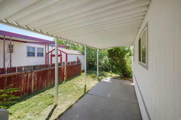 Covered concrete patio extending along the side of the property