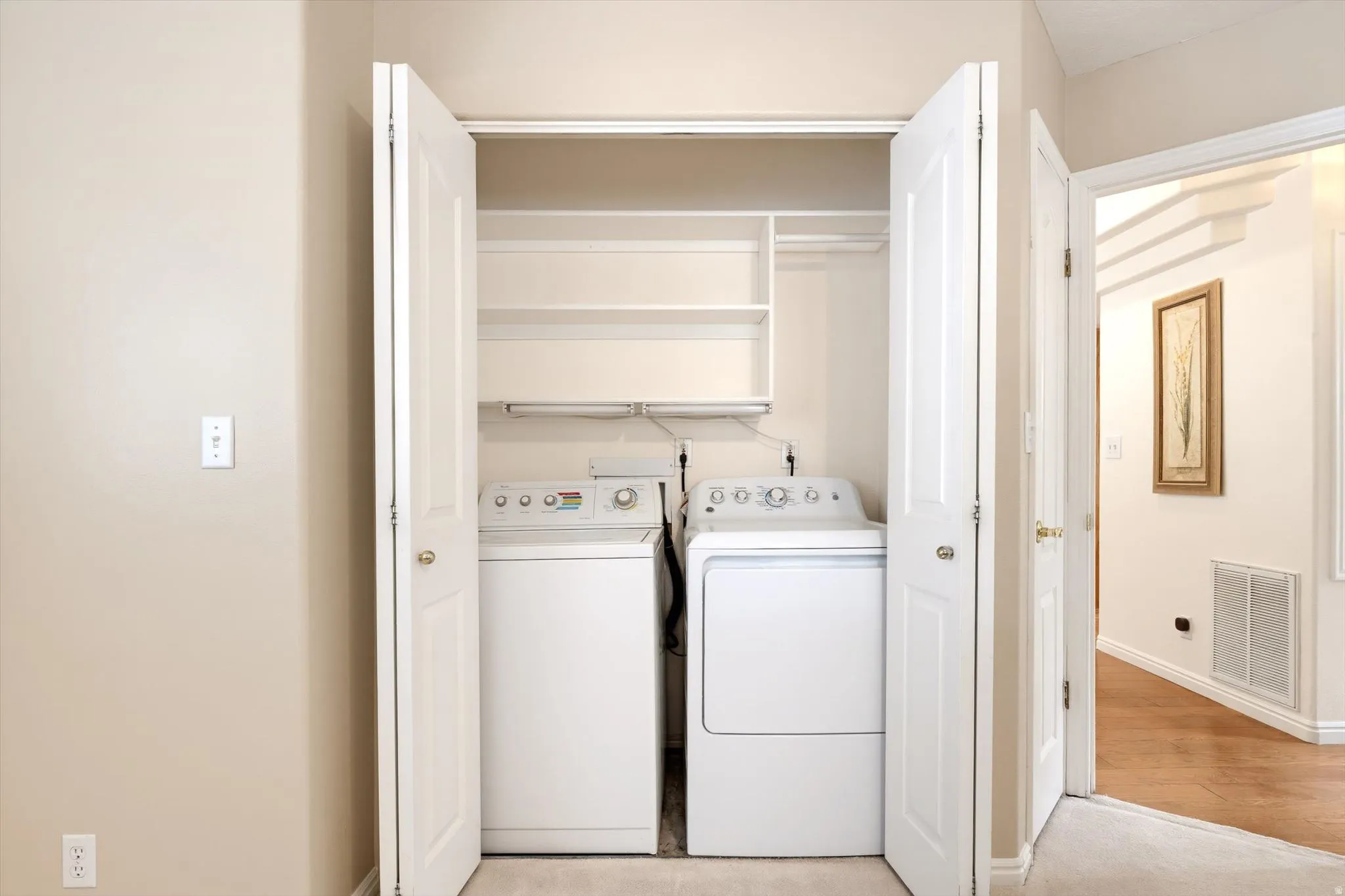 Built-in laundry closet featuring shelving and a clothing rod