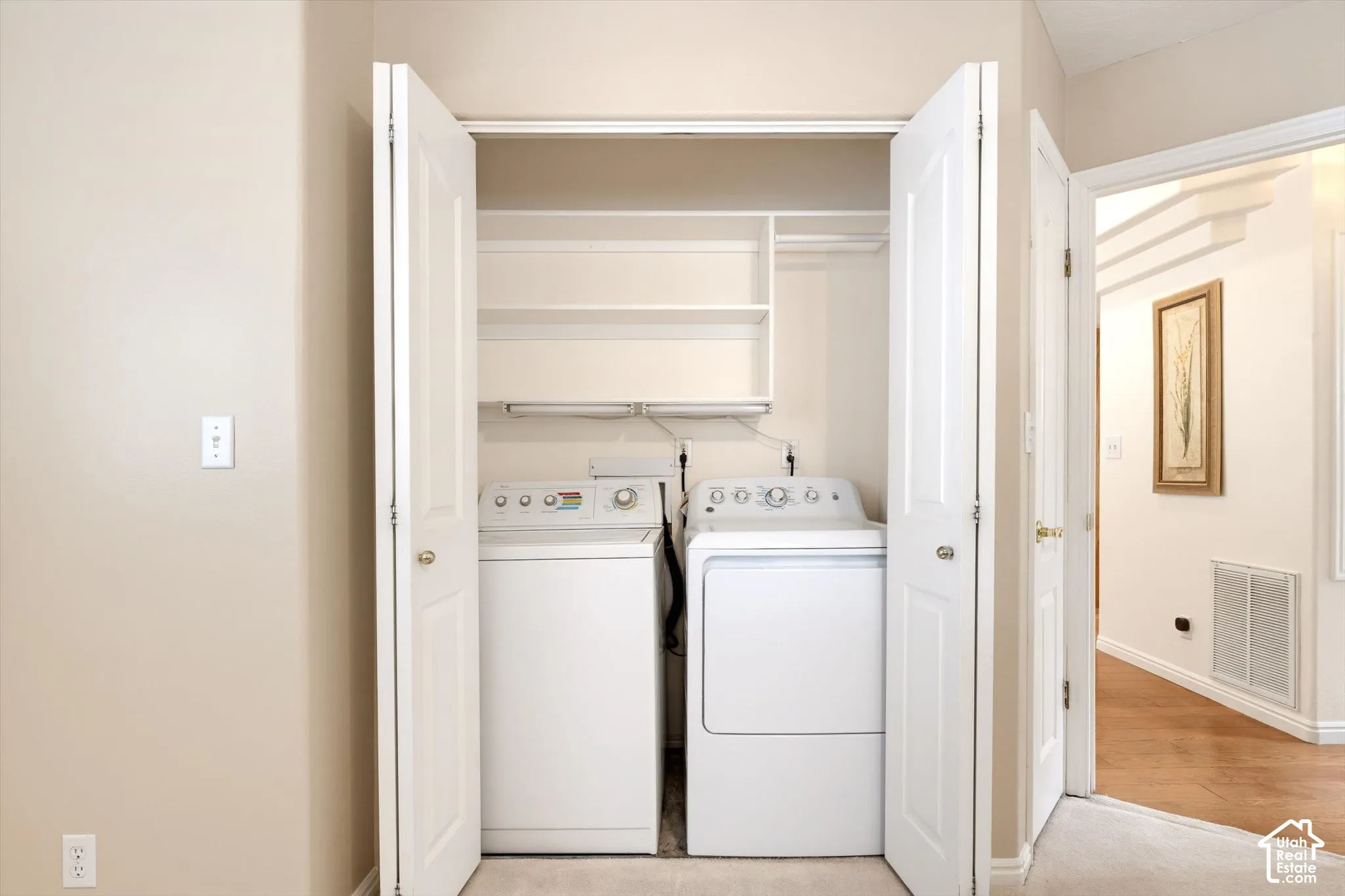 Built-in laundry closet featuring shelving and a clothing rod