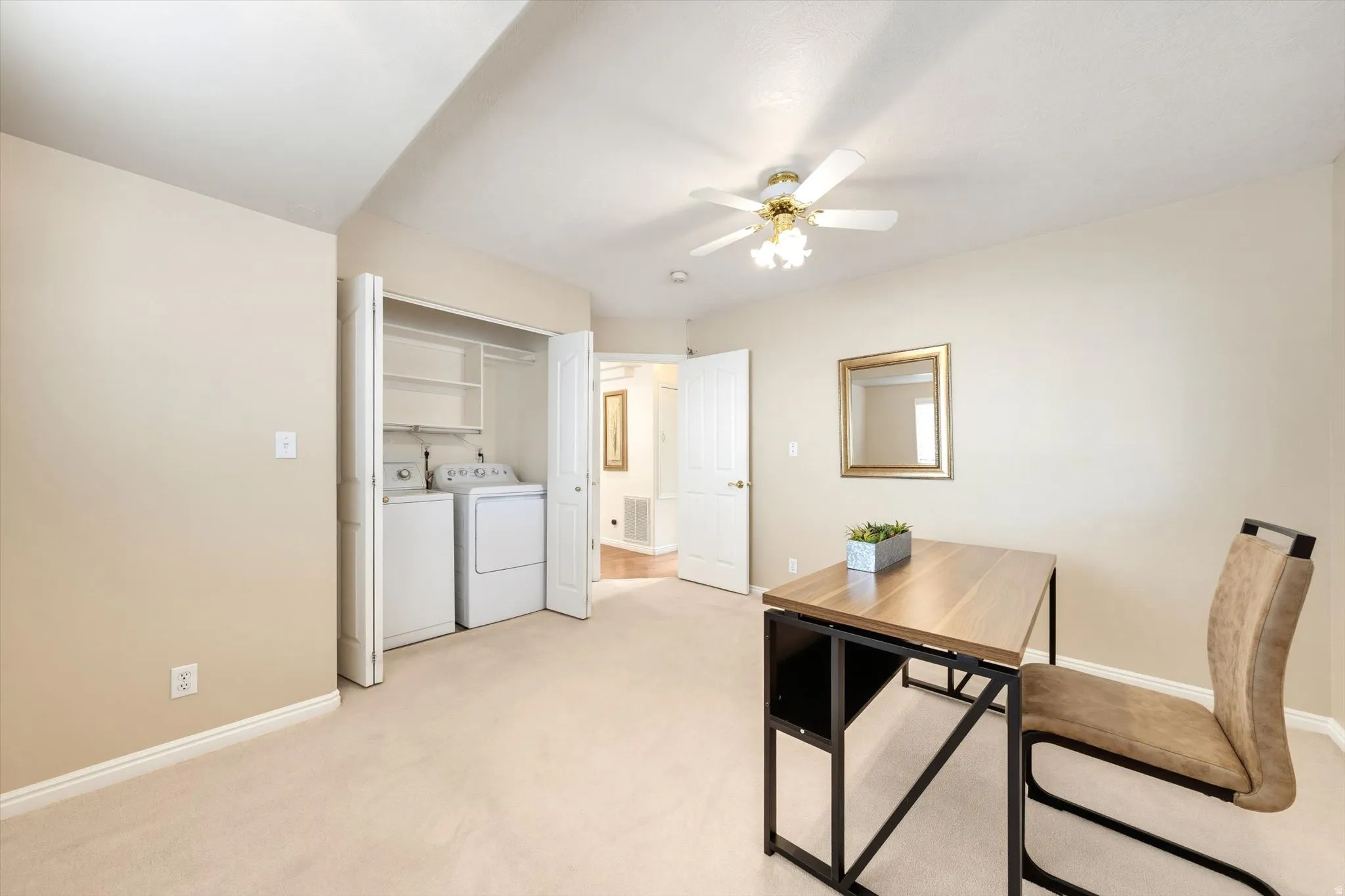 Plush carpet flooring, ceiling fan with integrated lighting, laundry closet with shelving, and interior door with white trim