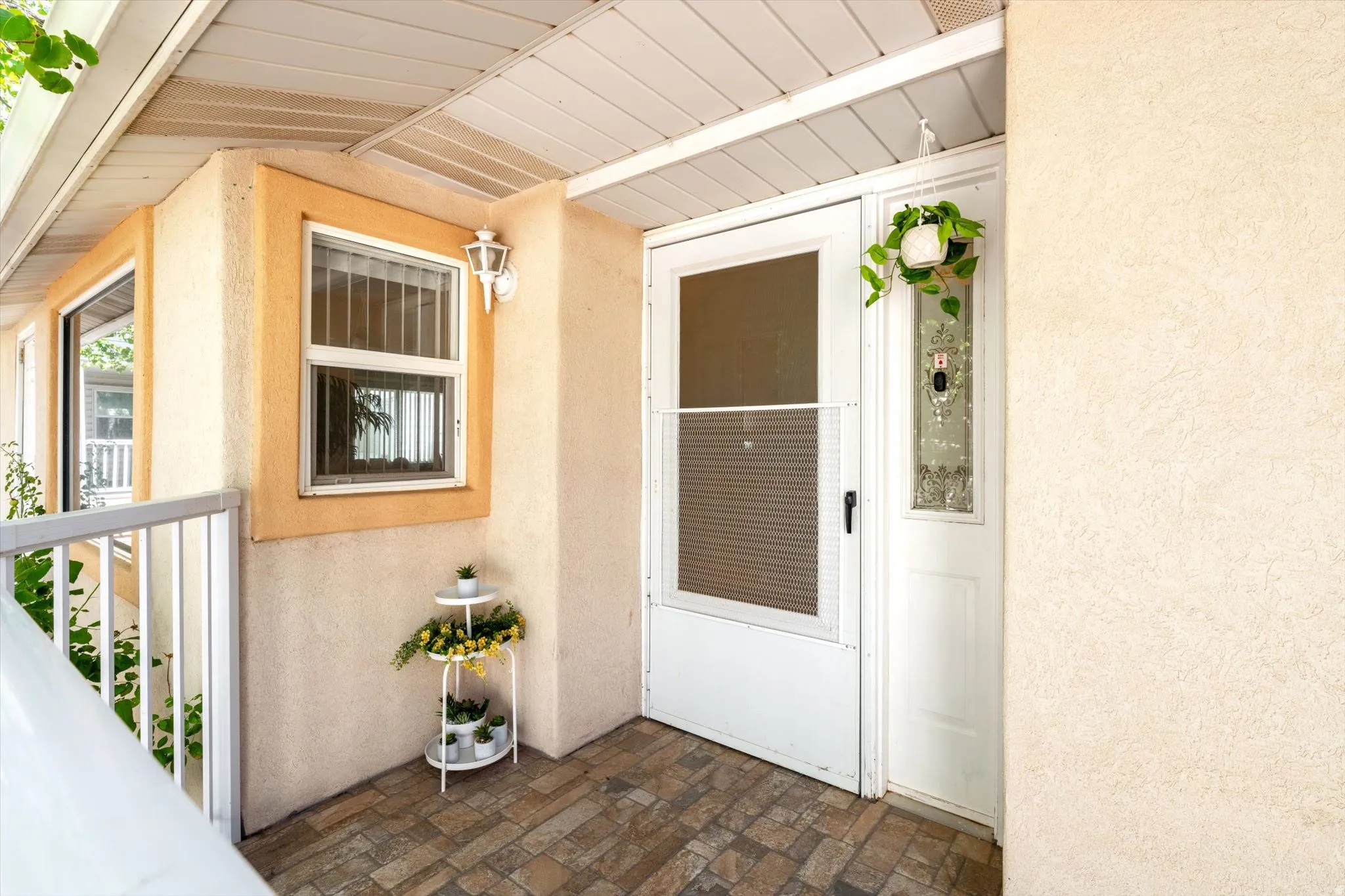 Front entry featuring a security screen door, decorative glass sidelight, and an exterior wall sconce