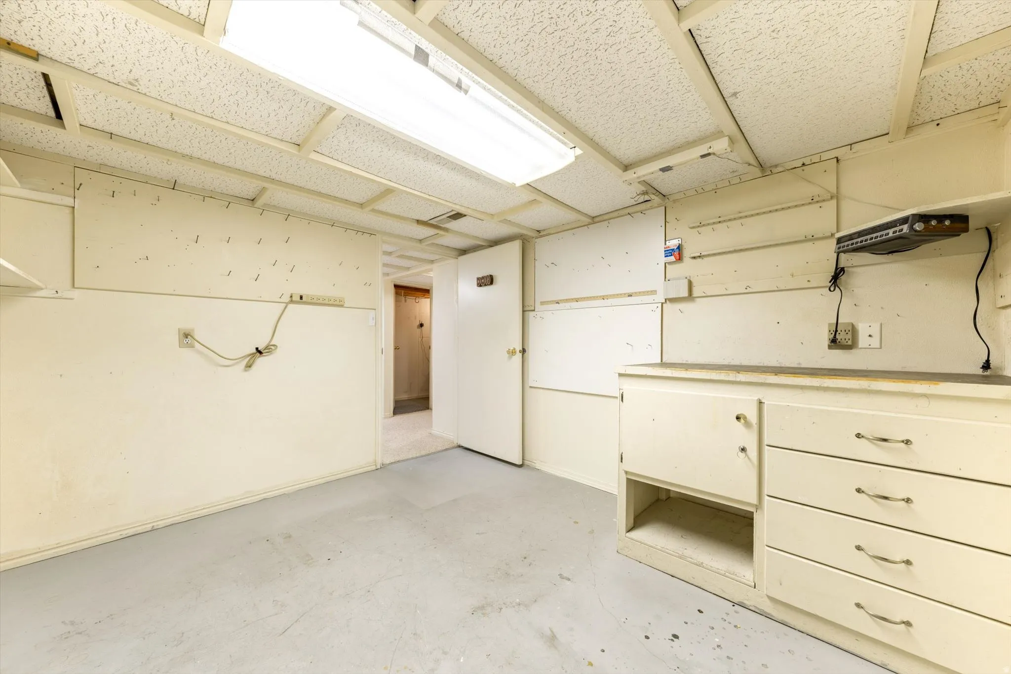 Built-in cabinetry with drawers, recessed shelving, and drop ceiling panels