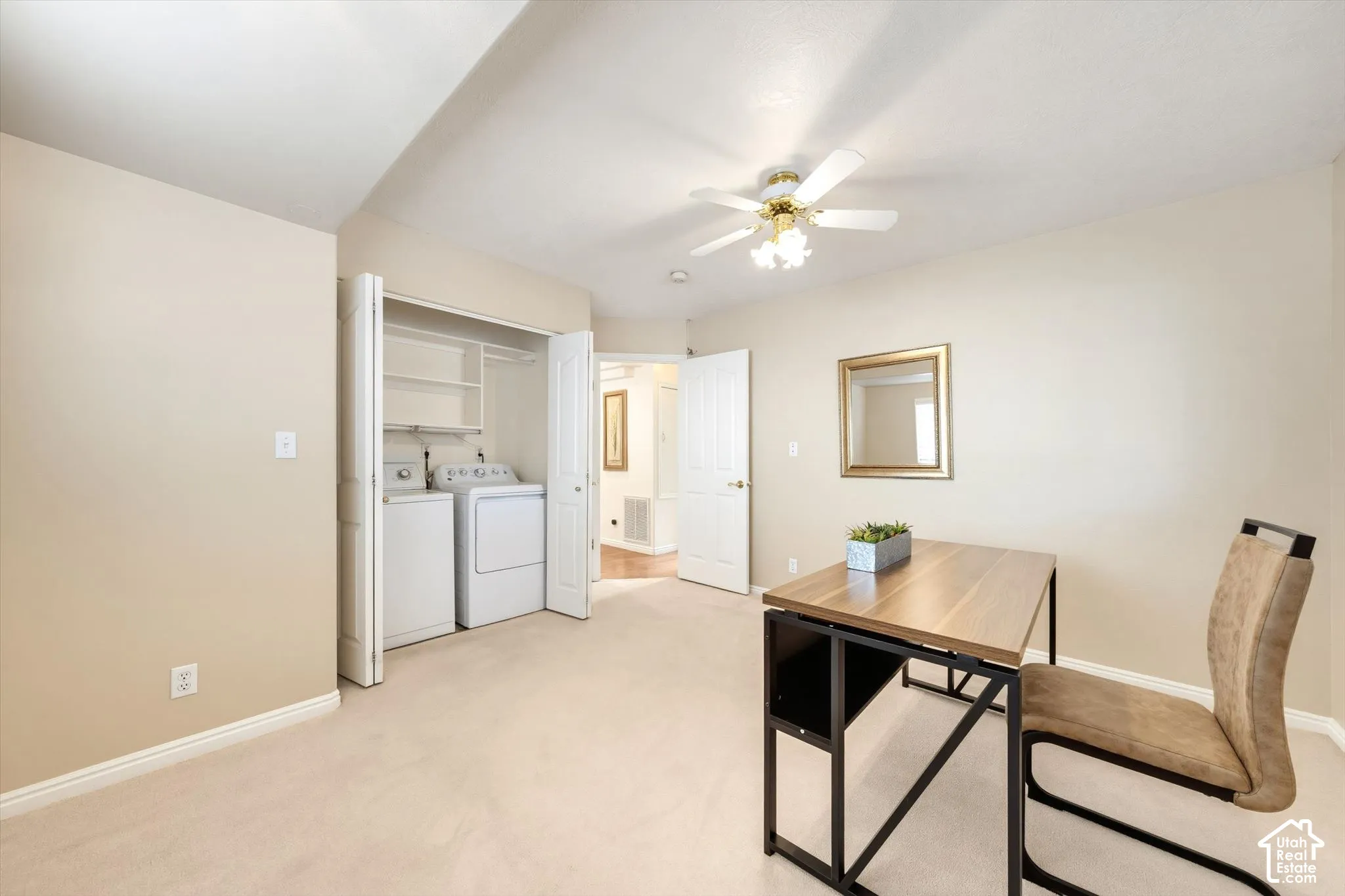 Plush carpet flooring, ceiling fan with integrated lighting, laundry closet with shelving, and interior door with white trim