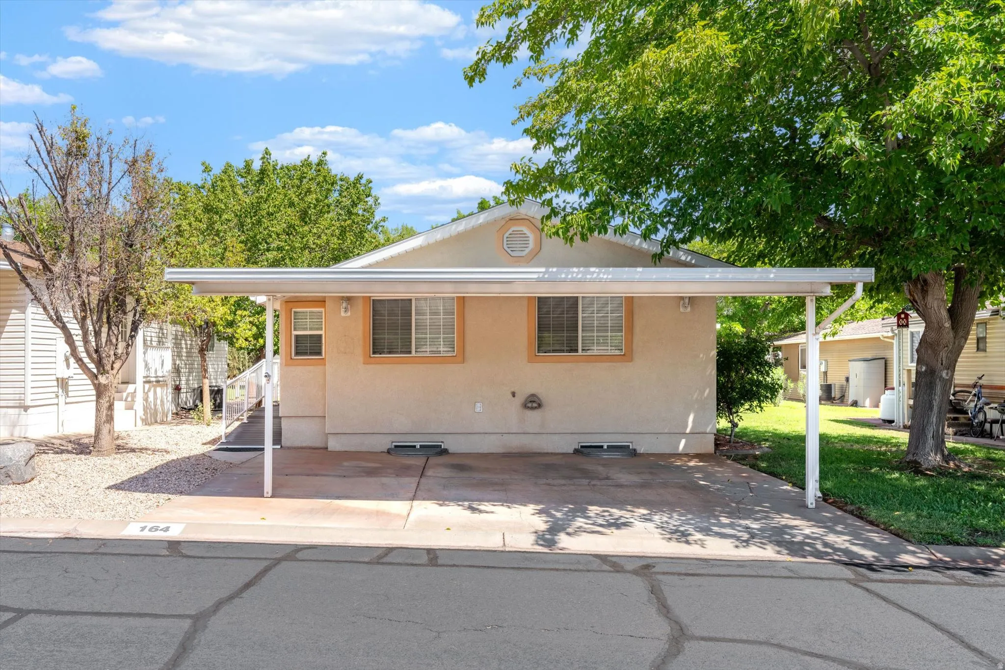 Single-story exterior with a covered carport, stucco finish, and multiple windows