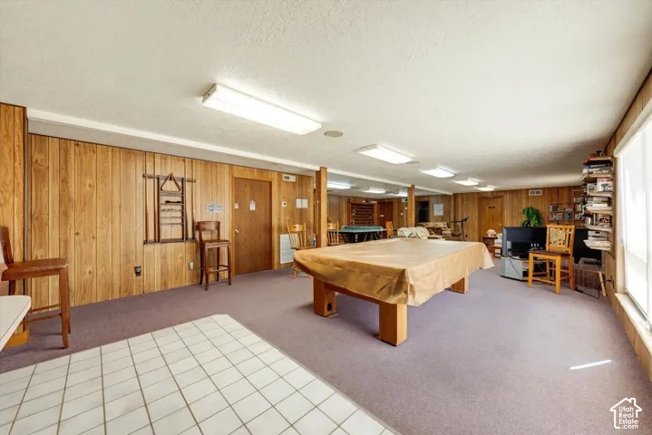 Spacious room featuring wood-finish wall paneling, a large window, and recessed lighting
